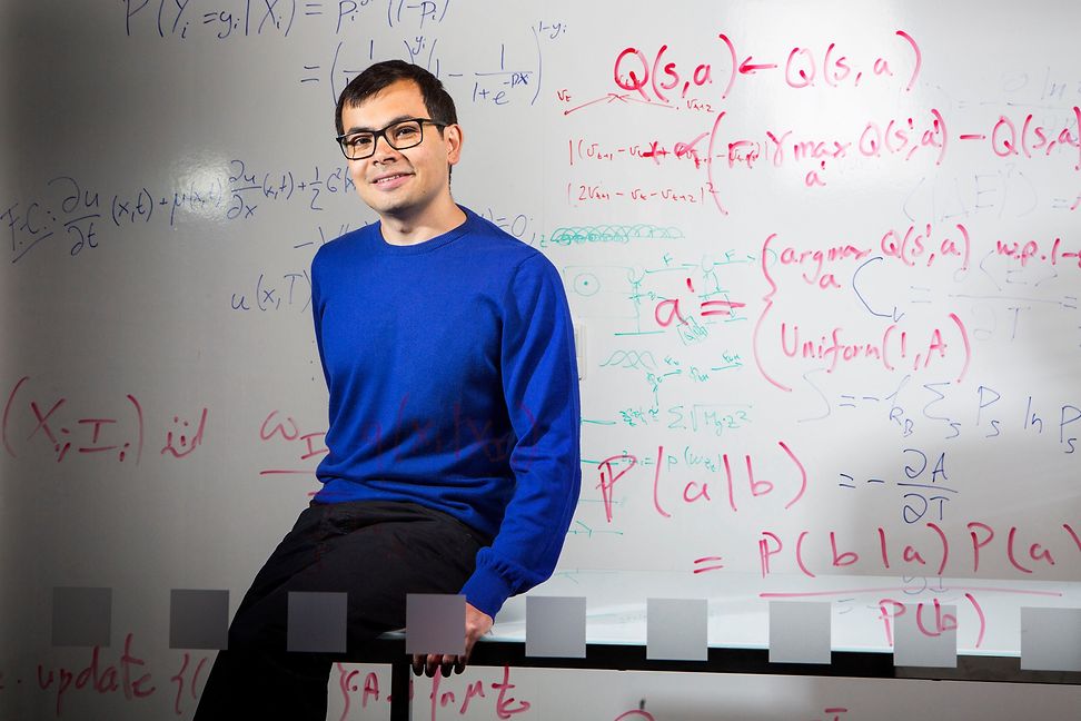 Demis Hassabis in front of a whiteboard