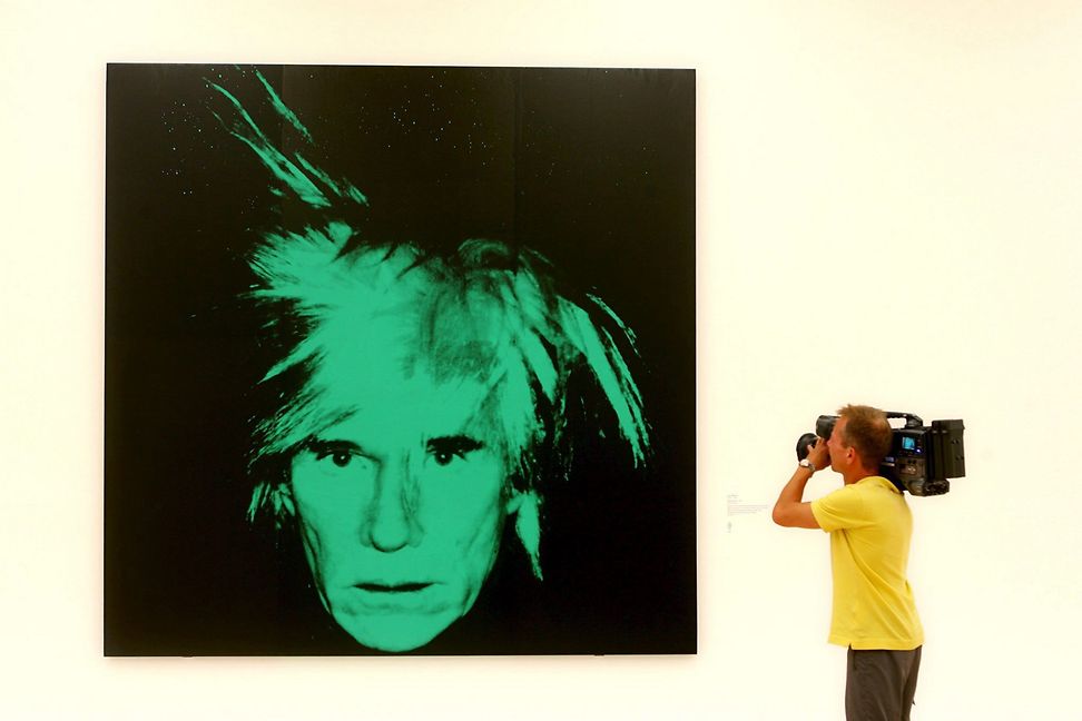 A cameraman films the self portrait of Andy Warhol