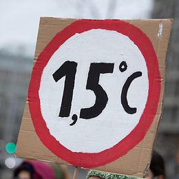 A protester holds up a 1.5 degrees sign