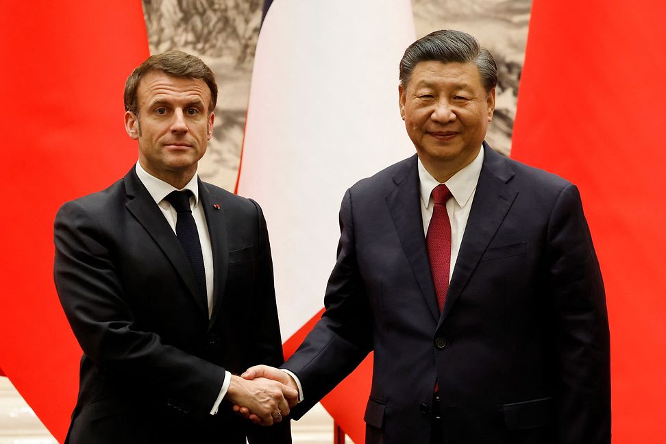 Der französische Präsident Emmanuel Macron und sein chinesischer Amtskollege Xi Jinping reichen sich in Peking die Hände.