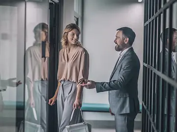 Man holds up door for woman