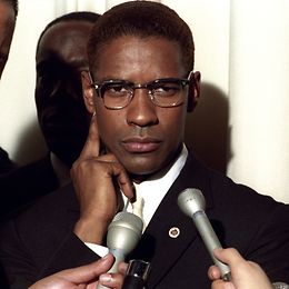 Denzel Washington schaut als Malcolm X in die Kamera