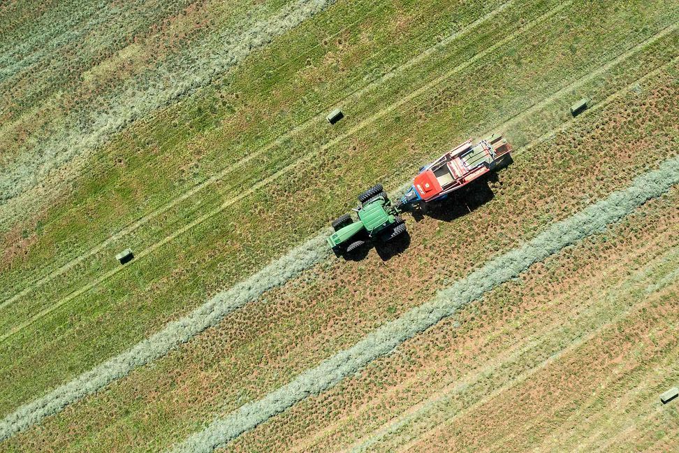 Aerial view of a rancher baling hay in an alfalfa field on a ranch in the desert near Moab, Utah.
