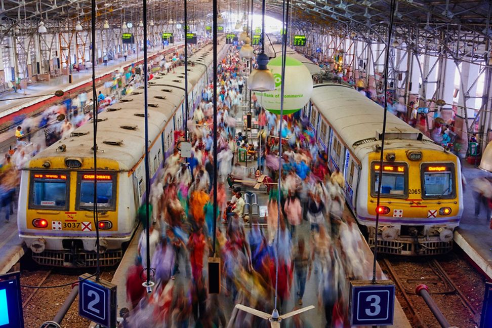 Two trains and passengers at Victoria Terminus, a railway station in Mumbai