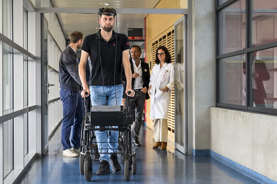 Der querschnittsgelähmte niederländische Patient Gert-Jan geht mit Hilfe eines Gehirnimplantats an einem Rollator. 