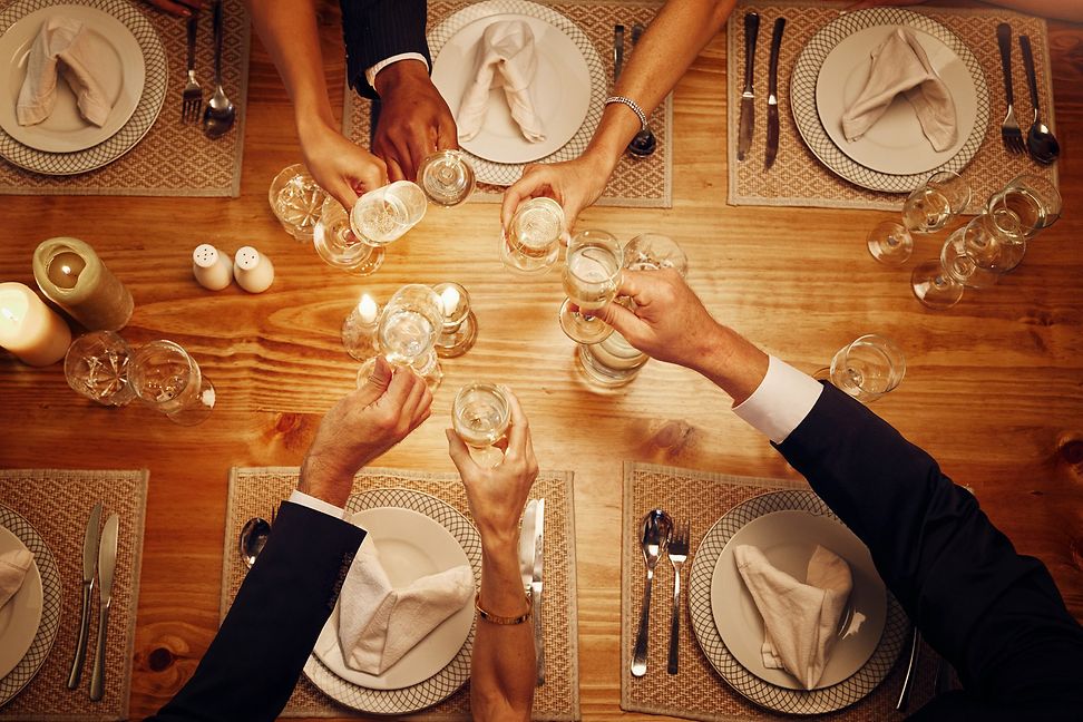 People clinking glasses during a dinner