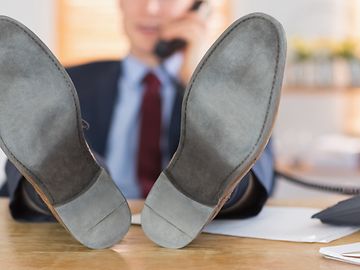 Businessman with his shoes on his desk