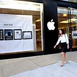 A person walks past a large Apple Store