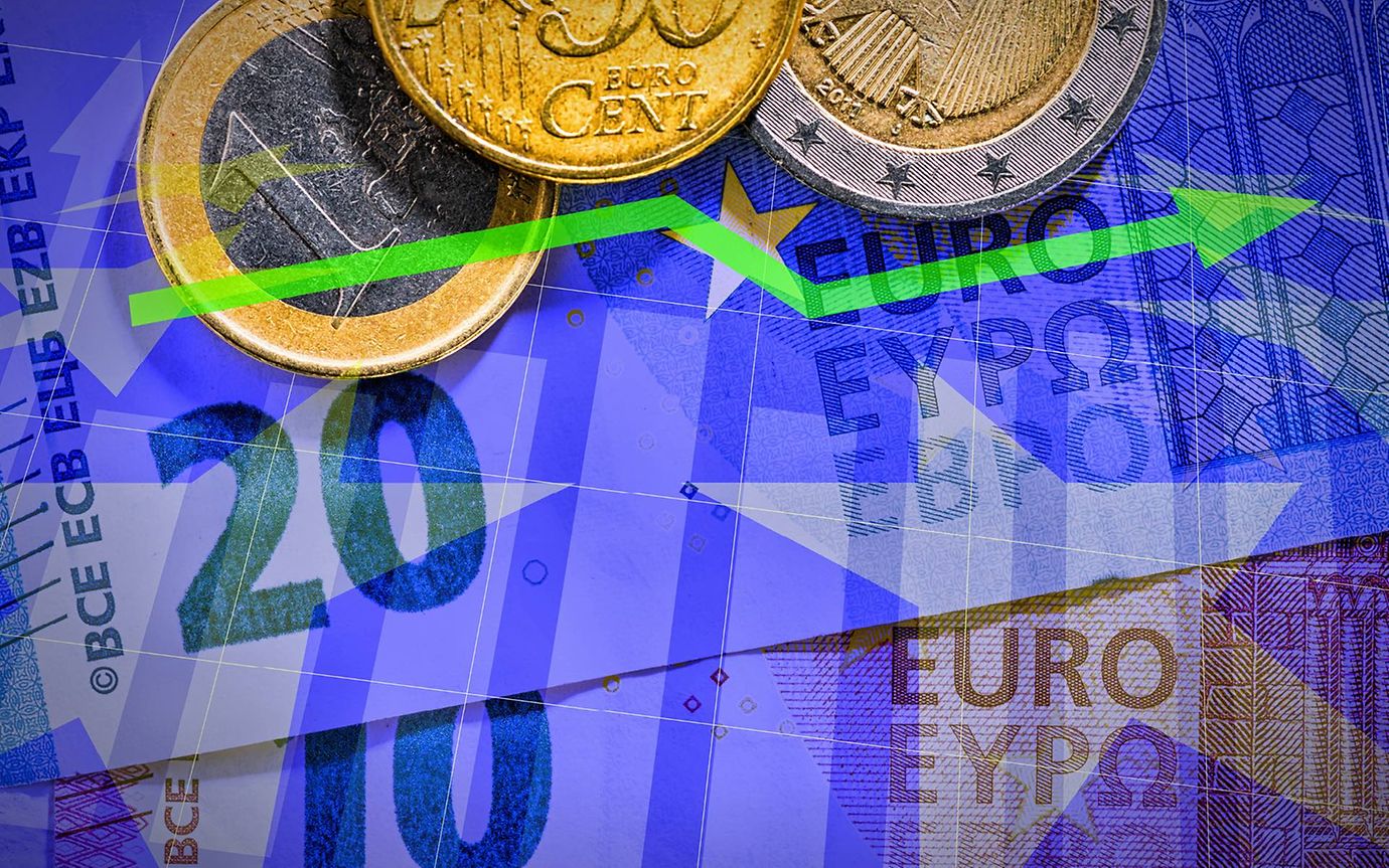 Euro banknotes and coins against an upward-pointing chart
