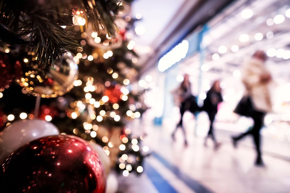 Menschen in einem Einkaufszentrum gehen an einem geschmÃ¼ckten Weihnachtsbaum vorbei