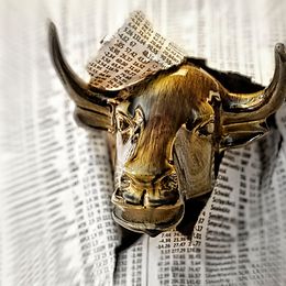 A metal bull crashes through a newspaper with stock market prices 