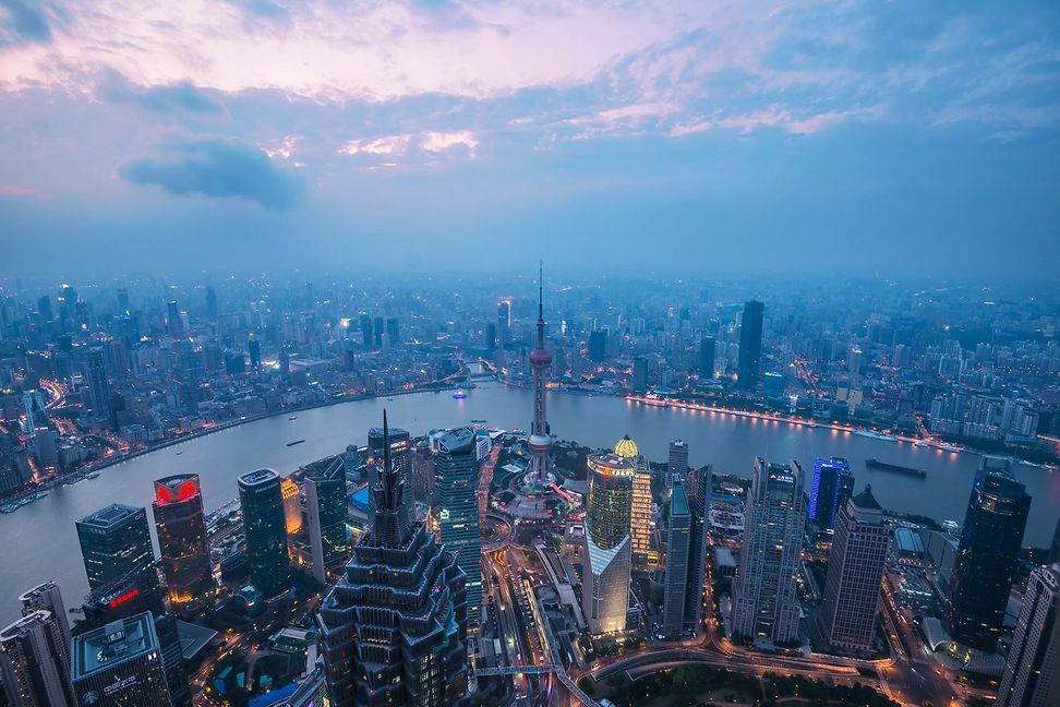 Vogelperspektive auf Shanghai und den Huangpu-Fluss zur blauen Stunde