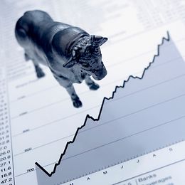 A bull figure on a page with stock prices and charts