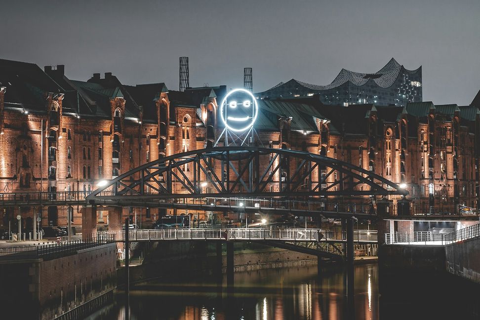 Die Kibbelstegbrücke in Hamburg am Hafen bei Nacht mit einem Neon-Smiley 
