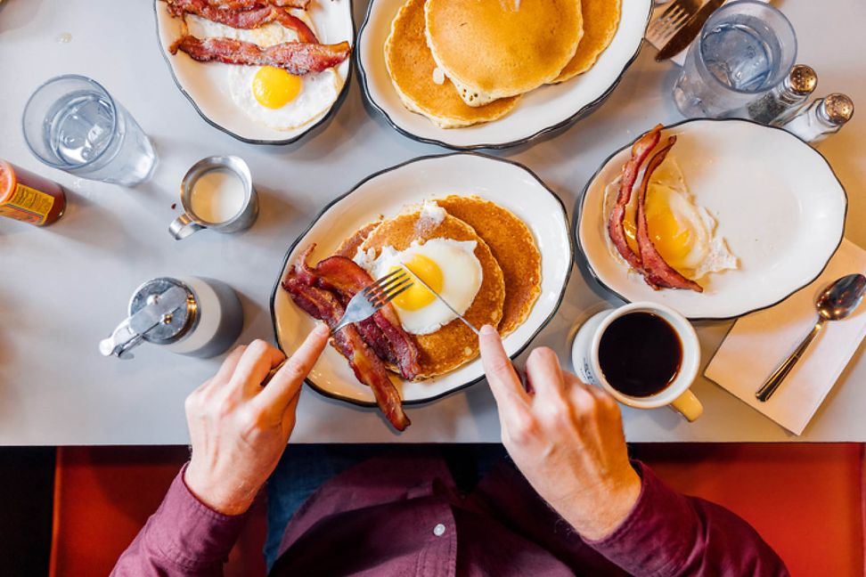 A typical American breakfast of eggs, bacon, pancakes and coffee from a bird's eye view