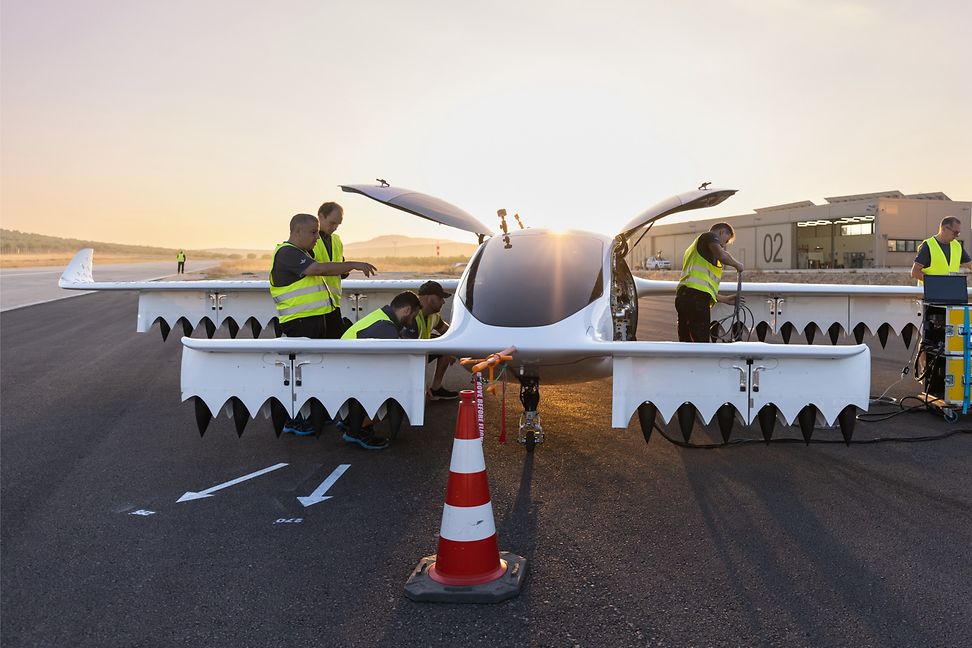 Ein modernes Flugzeug mit einer ungewöhnlichen Form, rundum Techniker