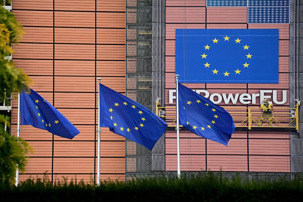 The EU flag flies in front of a large building with the word "Repower" on it.